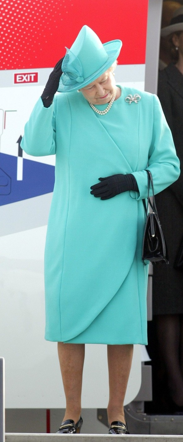 Britain&#039;s Queen Elizabeth II holds her hat as she arrives at the military part of the Tegel airport in Berlin on Tuesday Nov. 2, 2004. Queen Elisabeth stays for a three day state visit in Germany ...