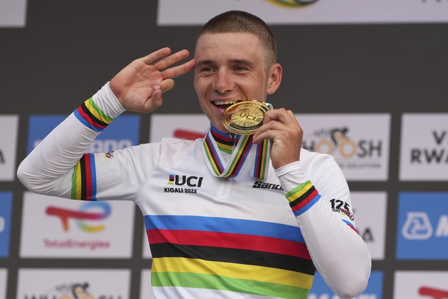 Belgium&#039;s Remco Evenepoel bites the gold medal after winning the men&#039;s elite individual time trial event, at the road cycling World Championships in Kigali, Rwanda, Sunday, Sept. 21, 2025. ( ...