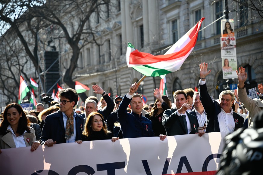 epa12821696 President of the opposition Tisza Party Peter Magyar (C) leads the National March during the national holiday to mark the 178th anniversary of the outbreak of the 1848 revolution and war o ...