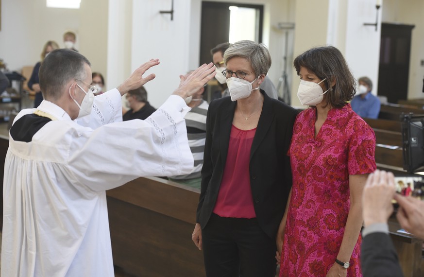 Vicar Wolfgang Rothe, left, blesses the couple Christine Walter, center, and Almut Muenster, right, during a Catholic service with the blessing of same-sex couples in St Benedict&#039;s Church in Muni ...