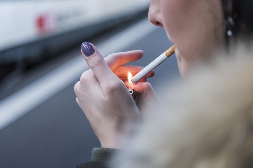 A female smoker on a plattform at Zurich main train station, in Zurich, Switzerland, on January 9, 2019. (KEYSTONE/Christian Beutler)