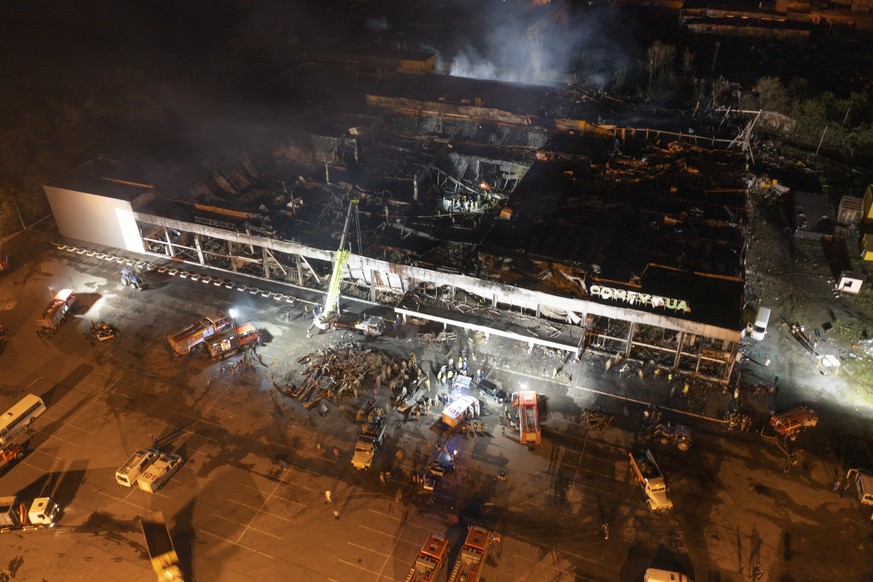 Ukrainian State Emergency Service firefighters work to extinguish a fire at a shopping center burned after a rocket attack in Kremenchuk, Ukraine, late Monday, June 27, 2022. (AP Photo/Efrem Lukatsky)