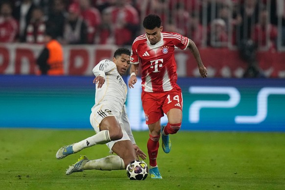 Bayern's Luis Diaz, right, is tackled by Real Madrid's Jude Bellingham during the Champions League quarterfinal second leg soccer match between Bayern Munich and Real Madrid in Munich, Germa ...
