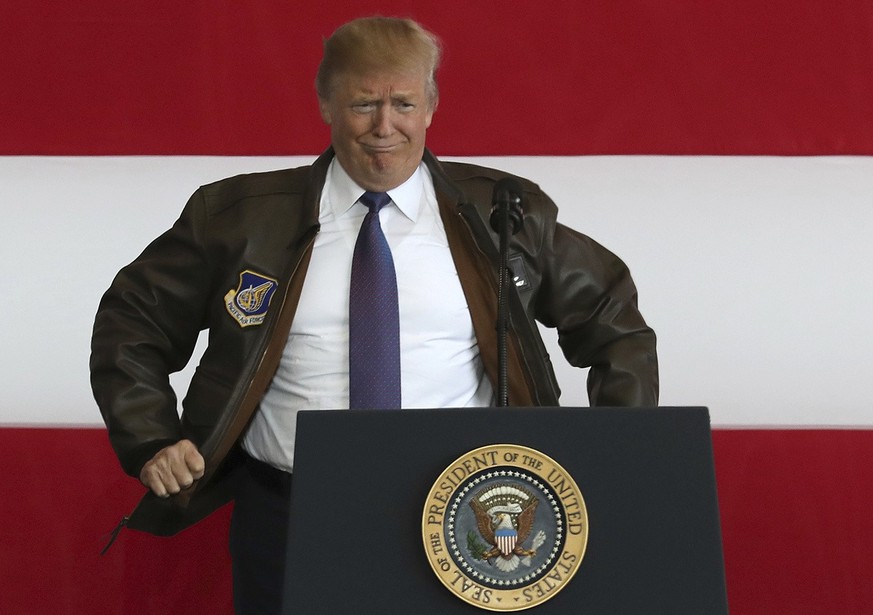 U.S. President Donald Trump puts on a military jacket as he meets the US troops at the U.S. Yokota Air Base, on the outskirts of Tokyo, Sunday, Nov. 5, 2017. President Trump arrived in Japan Sunday on ...