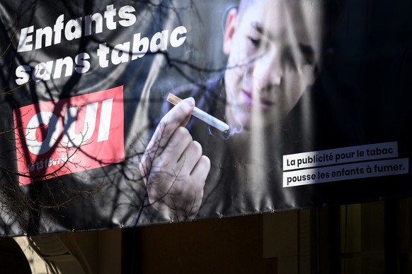 Une banderole representant une affiche &quot;Enfants sans tabac&quot; incitant a voter oui a l&#039;interdiction de la publicite pour le tabac qui pousse les enfants a fumer est photographiee ce mardi ...