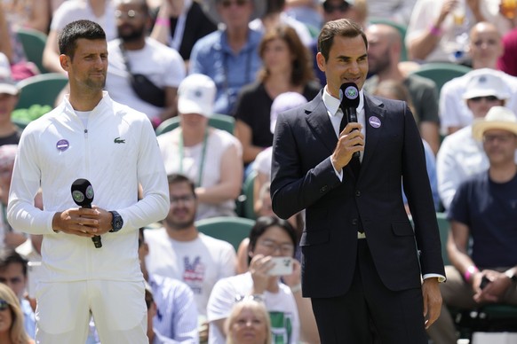 Switzerland&#039;s Roger Federer speaks, standing next to Serbia&#039;s Novak Djokovic during a 100 years of Centre Court celebration on day seven of the Wimbledon tennis championships in London, Sund ...