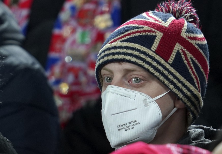 A fan wearing a face mask to protect against coronavirus looks out during the English Premier League soccer match between Liverpool and Newcastle United at Anfield stadium in Liverpool, England, Thurs ...