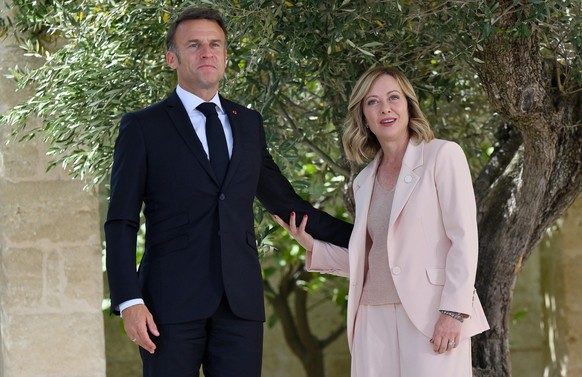epa11407583 Italy's Prime Minister Giorgia Meloni (R) greets French President Emmanuel Macron (L) during a welcome ceremony for the G7 summit in Borgo Egnazia, southern Italy, 13 June 2024. The 5 ...