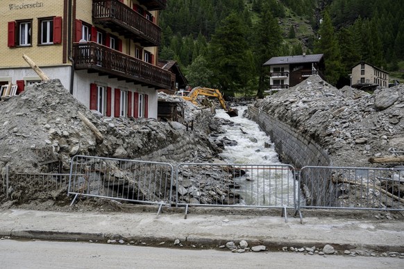 Une pelleteuse enleve des gravats dans le lit de la riviere Triftbach dans le village haut-valaisan ensevelie ce week-end par une lave torrentielle le mardi 2 juillet 2024 a Saas-Grund. (KEYSTONE/Jean ...