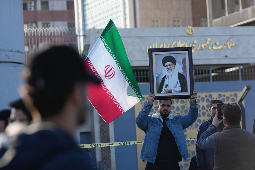 An Iraqi man holds a portrait of Iran's Supreme Leader Ayatollah Ali Khamenei, in front of the Iranian Embassy, during a rally to show solidarity with Iran and oppose the U.S. threats of a milita ...