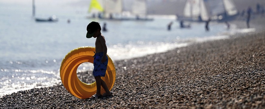 En ung mann nyter det varme været på Deal-stranden i Kent, søndag 10. september 2023, ettersom tordenvær vil ramme deler av Storbritannia midt i en rekordhøy hetebølge i september.  (Victoria Jones/PA via A...