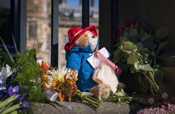 A Paddington Bear toy and marmalade sandwich is left amongst flowers and tributes outside the Palace of Holyroodhouse, following the death of Queen Elizabeth II on Thursday, in Edinburgh, Saturday, Se ...