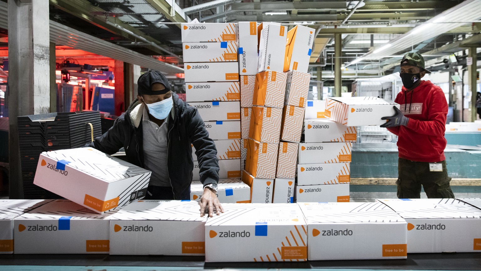 Angestellte der Post packen angelieferte Pakete der Firma Zalando auf ein Laufband im Paketzentrum Haerkingen, am Mittwoch, 9. Dezember 2020, in Haerkingen. (KEYSTONE/Peter Klaunzer)