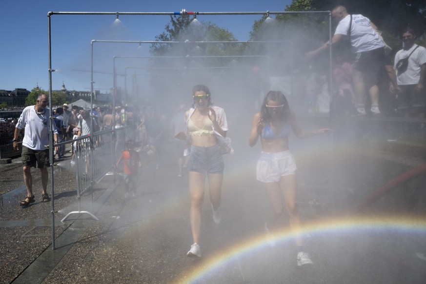 Participants cool off with a shower during the 33rd Street Parade in the city center of Zurich, Switzerland, Saturday, August 8, 2026. The annual dance music event Street Parade runs this year under t ...