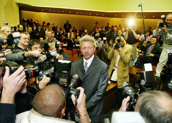 Former German Tennis Star Boris Becker, center, is surrounded by journalists in a courtroom in Munich on Wednesday, Oct. 23, 2002. Becker is accused of tax evasion. (AP Photo/Jan Pitman)