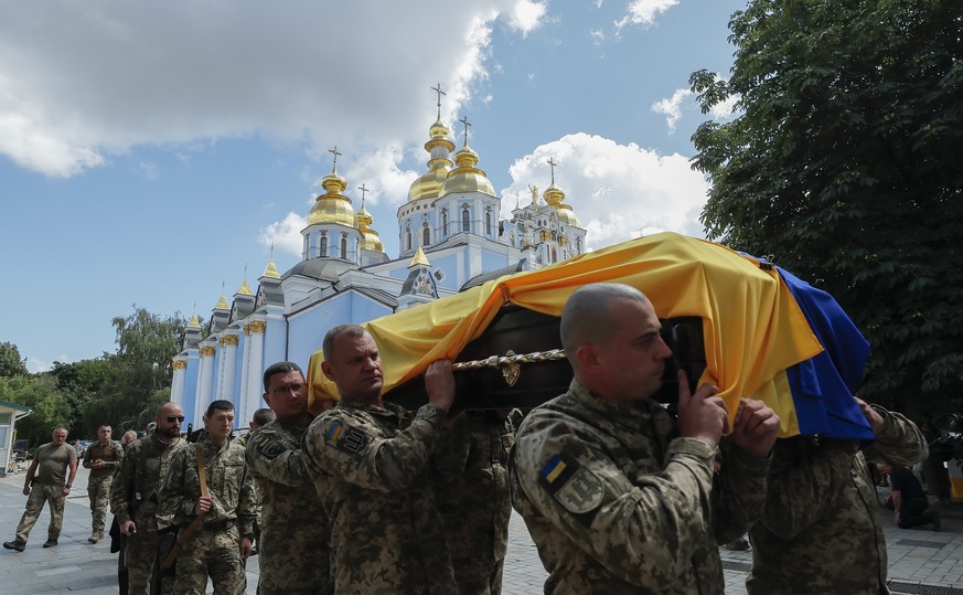 epa10077557 Ukrainian soldiers carry the coffin covered with a national flag during the funeral ceremony for a Ukrainian serviceman nicknamed &#039;Fanat&#039;, at St. Michael&#039;s Golden-Domed Mona ...