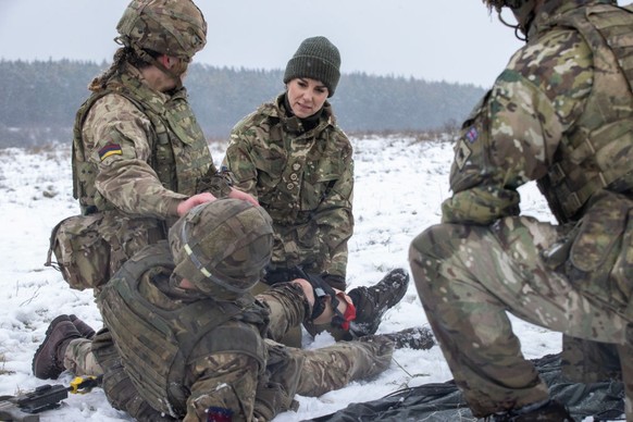 SALISBURY, ENGLAND - MARCH 08: Catherine, Princess of Wales assists L/Cpl Jodie Newell tend to a &quot;wounded soldier&quot; in an exercise, during her visit to the Irish Guards on Salisbury Plain, on ...