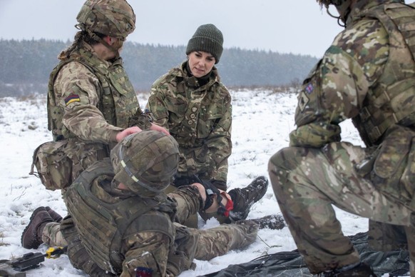 SALISBURY, ENGLAND - MARCH 08: Catherine, Princess of Wales assists L/Cpl Jodie Newell tend to a "wounded soldier" in an exercise, during her visit to the Irish Guards on Salisbury Plain, on ...