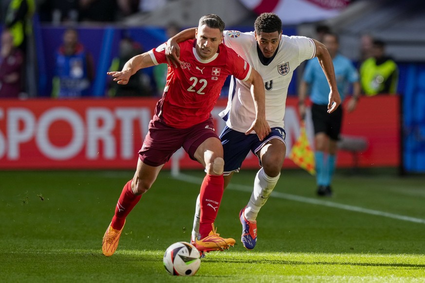 Switzerland's Fabian Schar, left, fights for the ball with England's Jude Bellingham during the quarterfinal match between England and Switzerland at the Euro 2024 soccer tournament in Duess ...