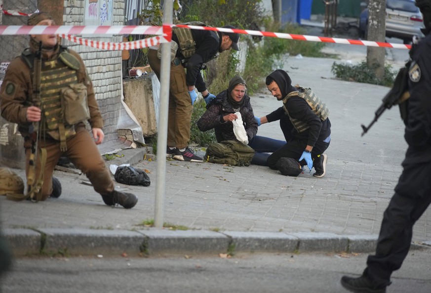 Medics help injured woman after after a drone fired on buildings in Kyiv, Ukraine, Monday, Oct. 17, 2022. (AP Photo/Efrem Lukatsky)