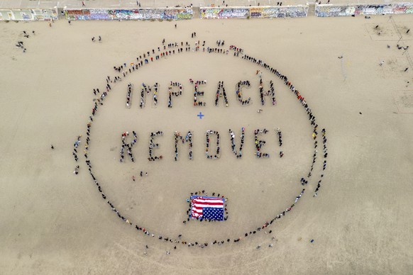 Protesters form a &quot;Impeach &amp; Remove&quot; human banner on Ocean Beach during a protest against U.S. President Donald Trump, in San Francisco, Saturday, April 19, 2025. (Stephen Lam/San Franci ...