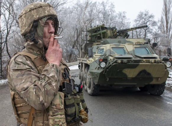 A Ukrainian soldier smokes a cigarette on his position at an armored vehicle outside Kharkiv, Ukraine, Saturday, Feb. 26, 2022. President Volodymyr Zelenskyy claimed Saturday that Ukraine&#039;s force ...