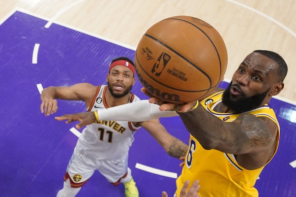 Los Angeles Lakers forward LeBron James, right, drives past Denver Nuggets forward Bruce Brown (11) in the first half of Game 4 of the NBA basketball Western Conference Final series Monday, May 22, 20 ...
