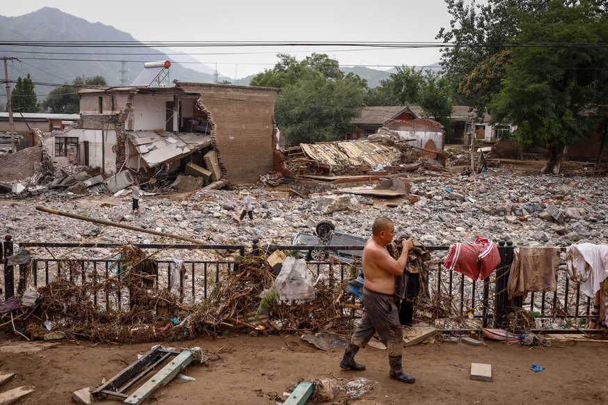 epaselect epa10783998 Mr. Sun recovers belongings from his house following strong rains and floods in the mountains of Mentougou District, west of Beijing, China, 04 August 2023. Beijing recorded its  ...