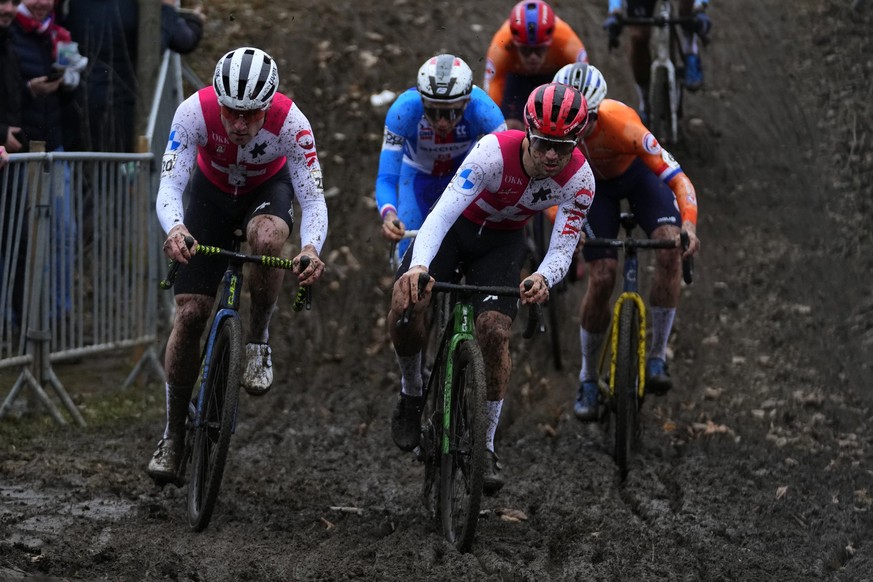 Kevin Kuhn of Switzerland, left, and Loris Rouiller of Switzerland, right, competes during the men's Cyclocross World Championships in Tabor, Czech Republic, Sunday, Feb. 4, 2024. (AP Photo/Petr  ...