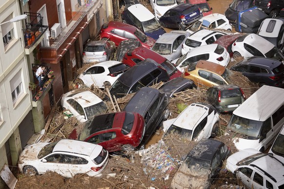 Residents look at cars piled up after being swept away by floods in Valencia, Spain, Wednesday, Oct. 30, 2024. (AP Photo/Alberto Saiz)