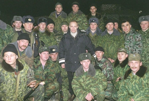 N362314 03: Acting Russian President Vladimir Putin stands with Russian soldiers during a concert after an awards ceremony in Gudermes, 30 km (19 miles) east of Grozny, Chechnya, January 1, 2000. Puti ...