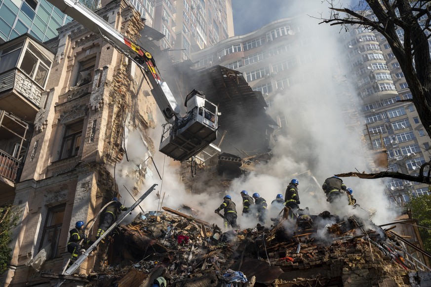 Firefighters work after a drone attack on buildings in Kyiv, Ukraine, Monday, Oct. 17, 2022. Waves of explosive-laden suicide drones struck Ukraine&#039;s capital as families were preparing to start t ...