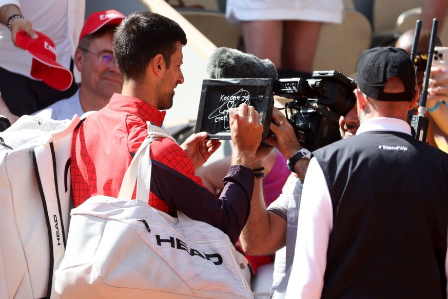 Novak Djokovic of Serbia writes in Serbian on the camera lens a political statement, &#039;Kosovo is the heart of Serbia. Stop the violence&#039; about the tensions between Kosovo and Serbia after his ...