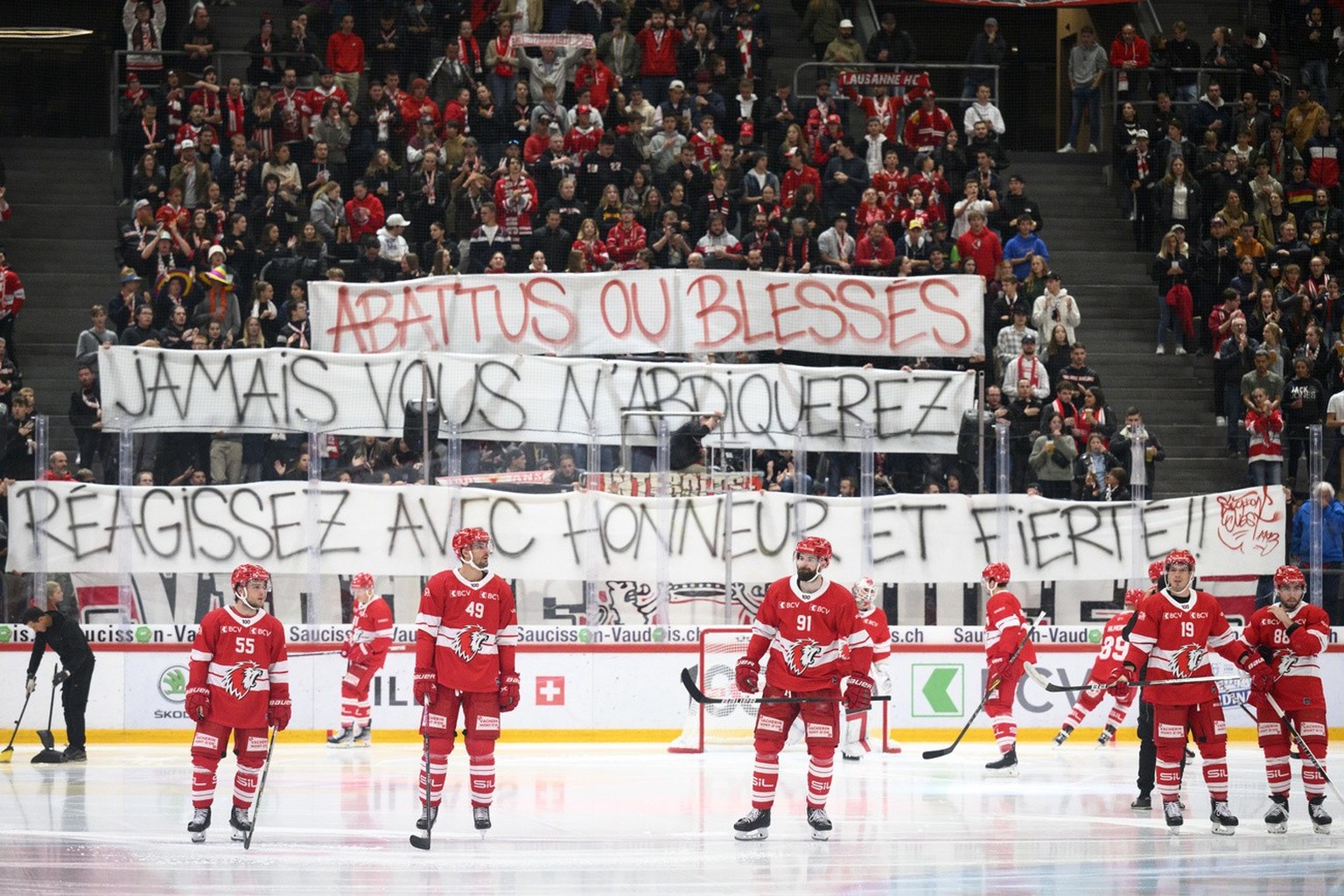 Les supporters lausannois accueillent les joueurs du LHC, en rouge, avec une banderole &quot;Abattus ou blesses, jamais vous n&#039;abdiquerez, reagissez avec honneur et fierte&quot; lors du match du  ...