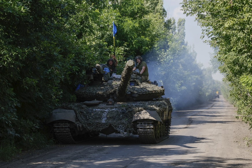 Des soldats ukrainiens brandissent leur drapeau national, près de Bakhmout.