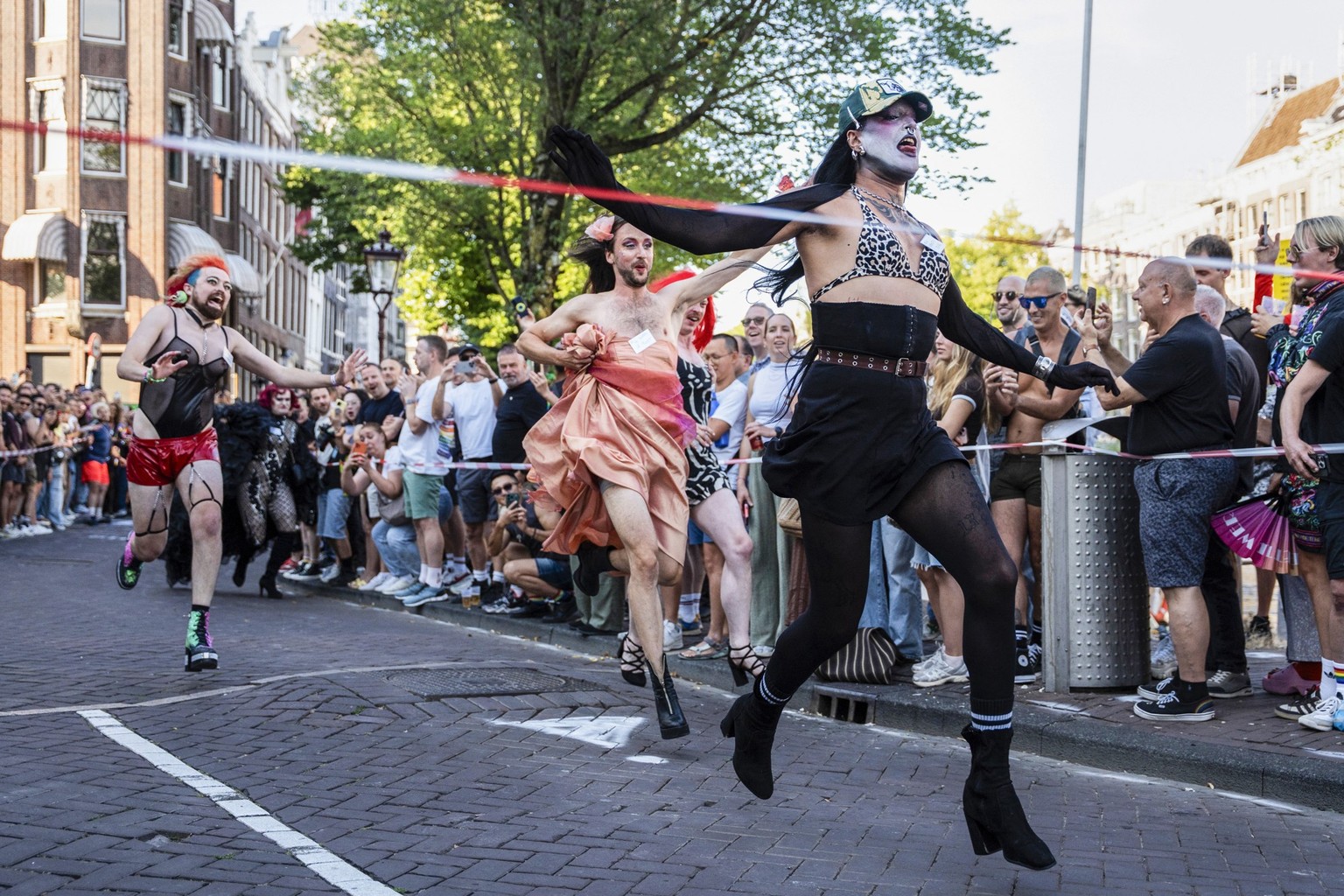 Des participants courent lors de la course en talons hauts organisée dans le cadre des « Drag Olympics » à Amsterdam, le 31 juillet 2026. (Photo : Lina Selg / AFP)