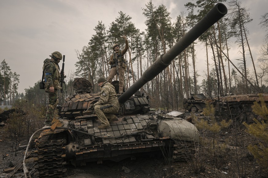 Un militaire ukrainien prend un selfie sur un char russe détruit, après que les forces ukrainiennes ont envahi une position russe à l'extérieur de Kiev, en Ukraine.