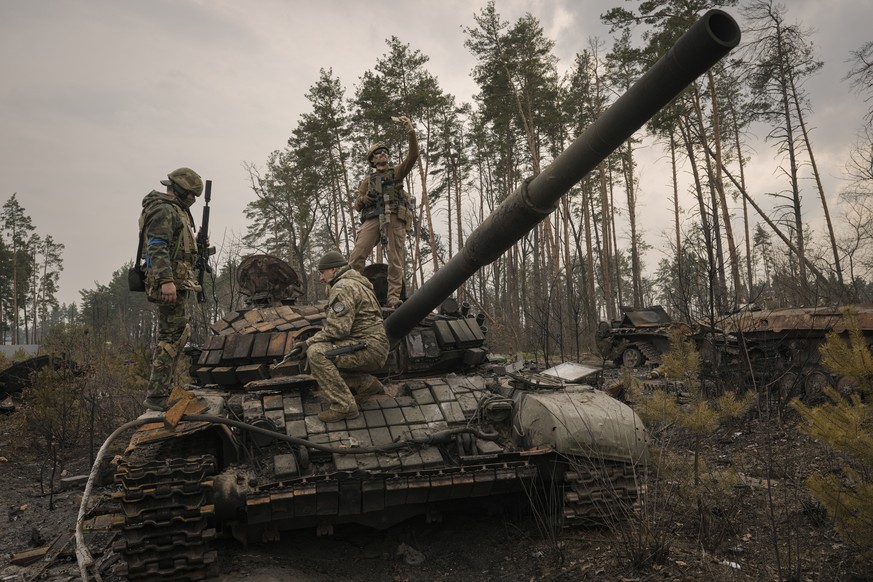 A Ukrainian serviceman takes a selfie standing on a destroyed Russian tank after Ukrainian forces overran a Russian position outside Kyiv, Ukraine, Thursday, March 31, 2022. (AP Photo/Vadim Ghirda)