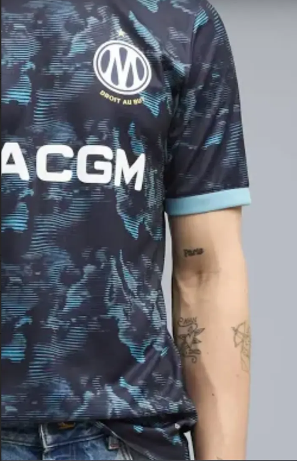 En zoomant, nous découvrons que le mannequin porte un tatouage Paris.