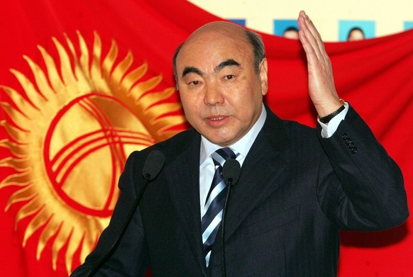 Kyrgyz President Askar Akayev gestures answering a question as he stands in front of national flag at a polling station in the Kyrgyz capital Bishkek Sunday, Feb. 27, 2005. Kyrgyzstan faced a key test ...
