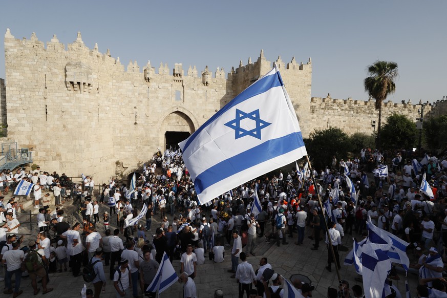 epa09984942 Participants carry Israeli flags during the Israeli right-wing &#039;Flag March&#039; next to the Damascus gate of Jerusalem&#039;s Old City, Jerusalem, 29 May 2022. The annual right-wing  ...