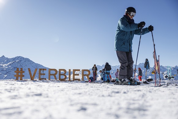 A skier rides past a wooden sign as they enjoy the snow and sunny weather during one of the first weekends after the opening of the ski season in the alpine resort of Verbier, Sunday, December 1, 2024 ...