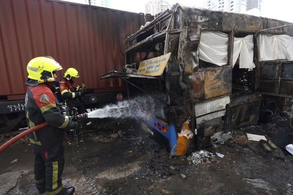 epa12962499 Thai rescue workers extinguish a fire on the wreckage of a public bus after it collided with a freight train at the Airport Rail Link's Makkasan station in Bangkok, Thailand, 16 May 2 ...