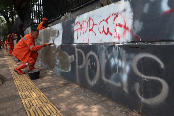 epa12341979 Workers remove graffiti after protests in front of the Parliament building in Jakarta, Indonesia, 01 September 2025. Protests erupted across the country following the death of a motorbike  ...