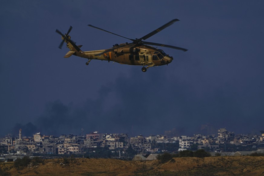 An Israeli military helicopter flies next to the Israeli-Gaza border, as seen from southern Israel, Wednesday, Dec. 6, 2023. (AP Photo/Ariel Schalit)