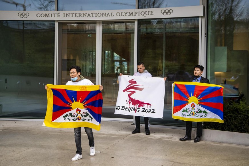 Protesters hold Tibetan flags during a protest against Beijing 2022 Winter Olympics by activists of the Tibetan Youth Association in Europe front of the International Olympic Committee, IOC, headquart ...