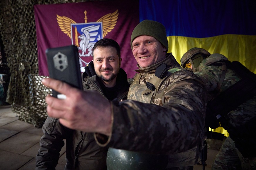 Le président ukrainien Volodymyr Zelensky (à gauche) pose avec un militaire dans la région de Donetsk.