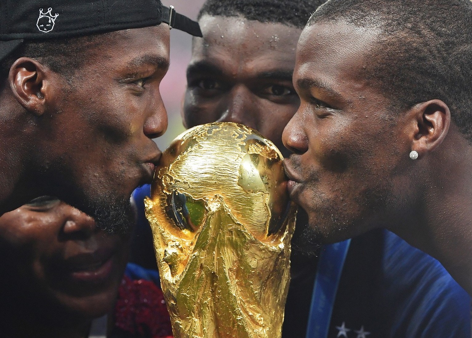 epa06893082 Paul Pogba (C) of France and his brothers Florentin (L), Mathias (R) and their mother Yeo celebrate with the World Cup trophy after the FIFA World Cup 2018 final between France and Croatia ...