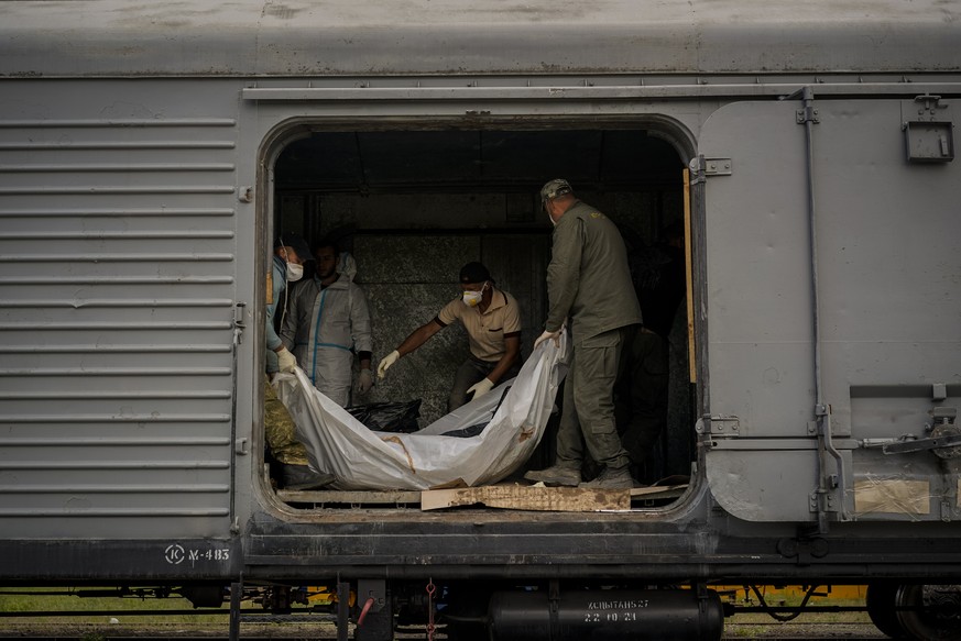 Forensic experts inspect bodies of dead Russian soldiers during an identification process in Kharkiv, east Ukraine, Tuesday, May 17, 2022. (AP Photo/Bernat Armangue)