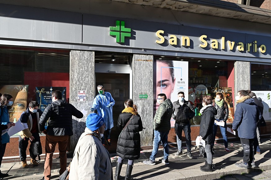 epa09651737 People queue up outside a pharmacy to undergo swab tests to detect Covid-19, in Turin, Italy, 20 December 2021. EPA/Alessandro Di Marco